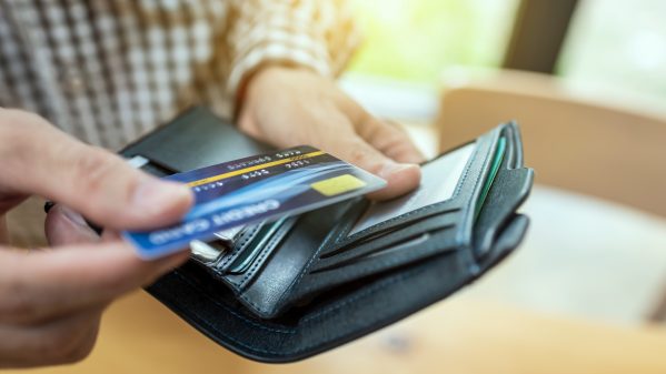 Young businessman giving credit card from wallet 